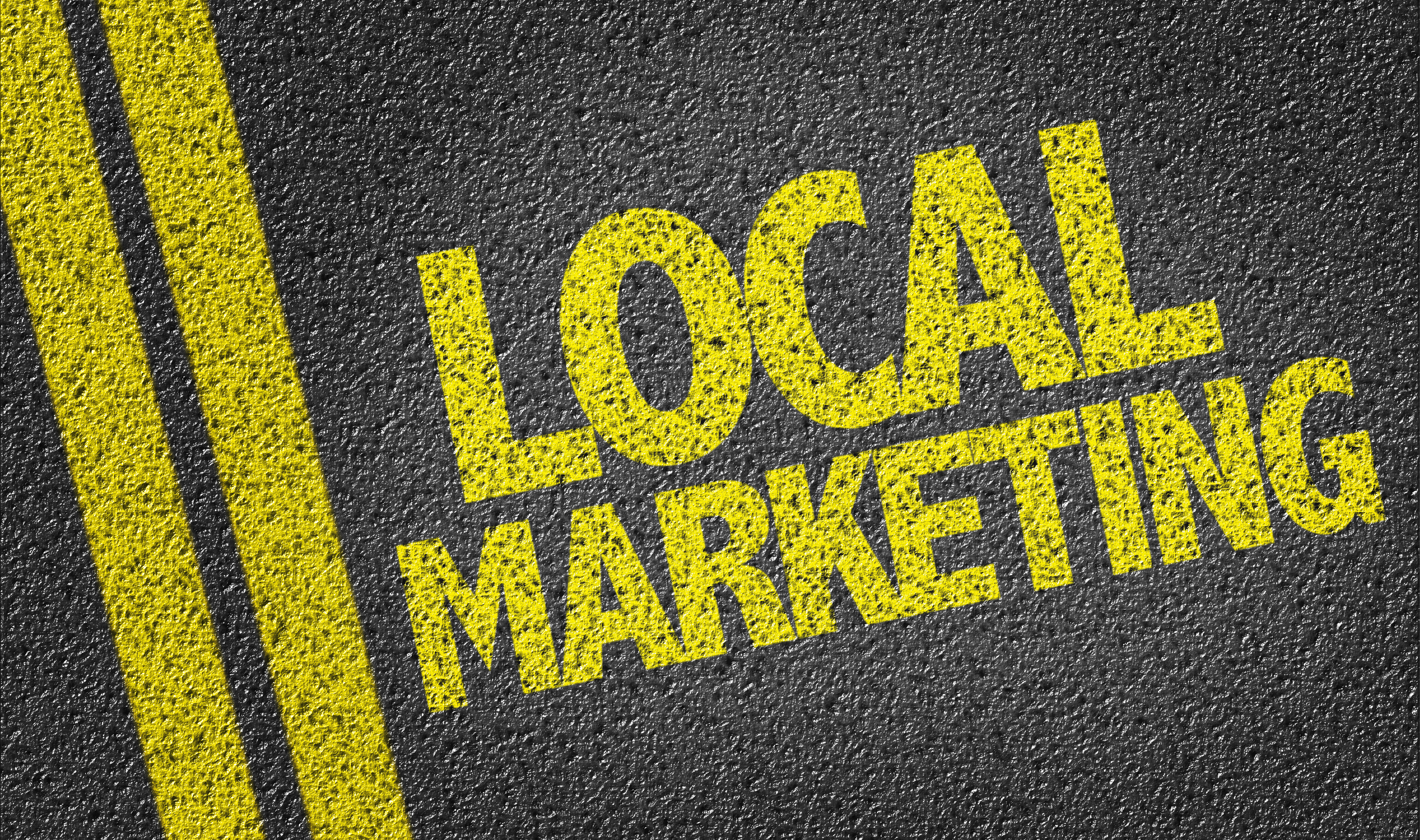 Local marketing text in bold yellow on dark asphalt background, emphasizing localized marketing strategies relevant to marketing asset management.