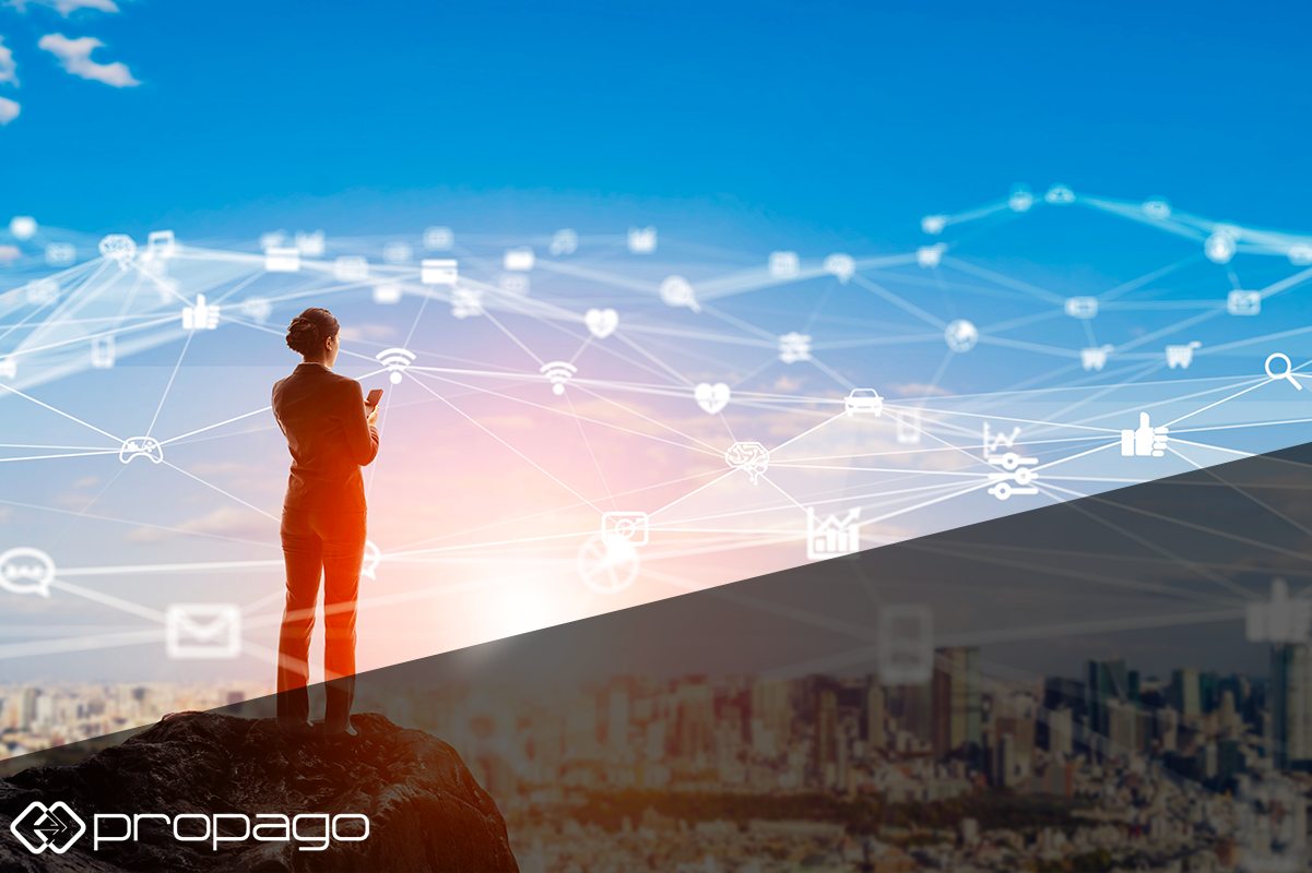 Business professional standing on a rock, using a smartphone, with digital networking icons and city skyline in the background, symbolizing online networking for remote print sales prospecting.