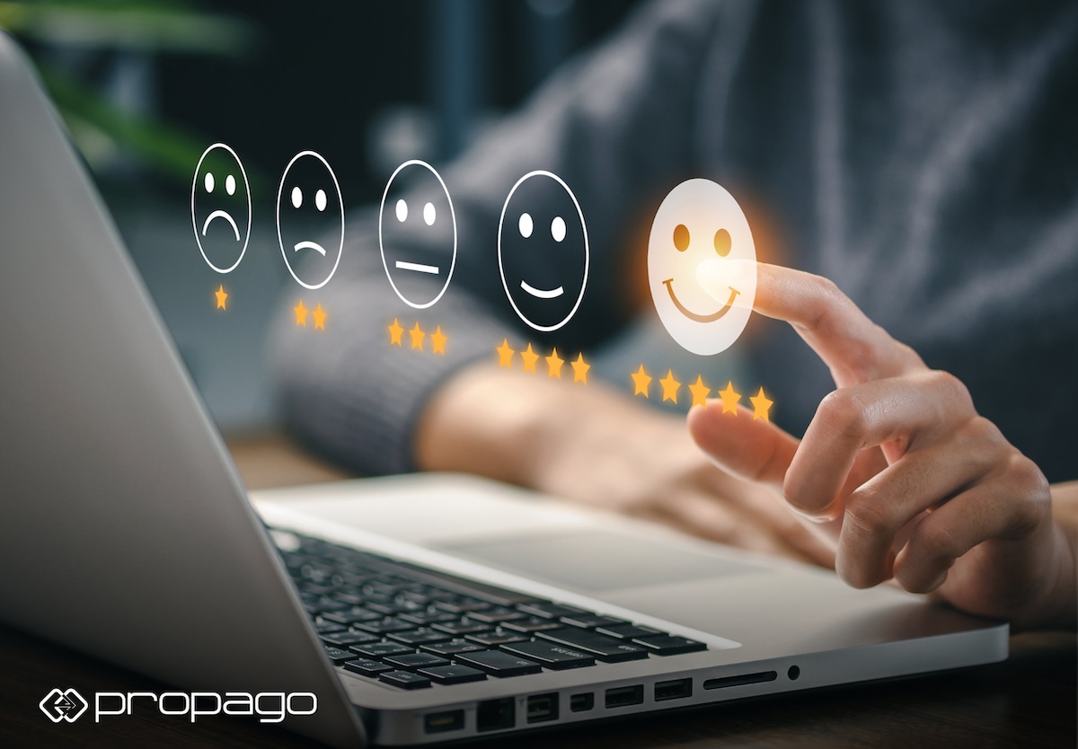 User interacting with a laptop to rate a web-to-print portal experience, featuring smiley face icons and star ratings, emphasizing user-centric design and engagement.