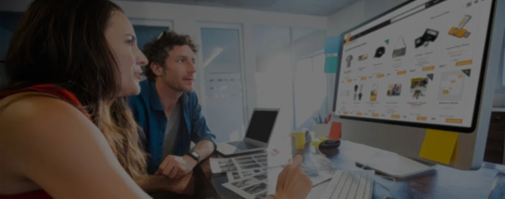 Two individuals engaging with a web-to-print platform on a large monitor, showcasing customizable print materials and marketing tools for brand management.